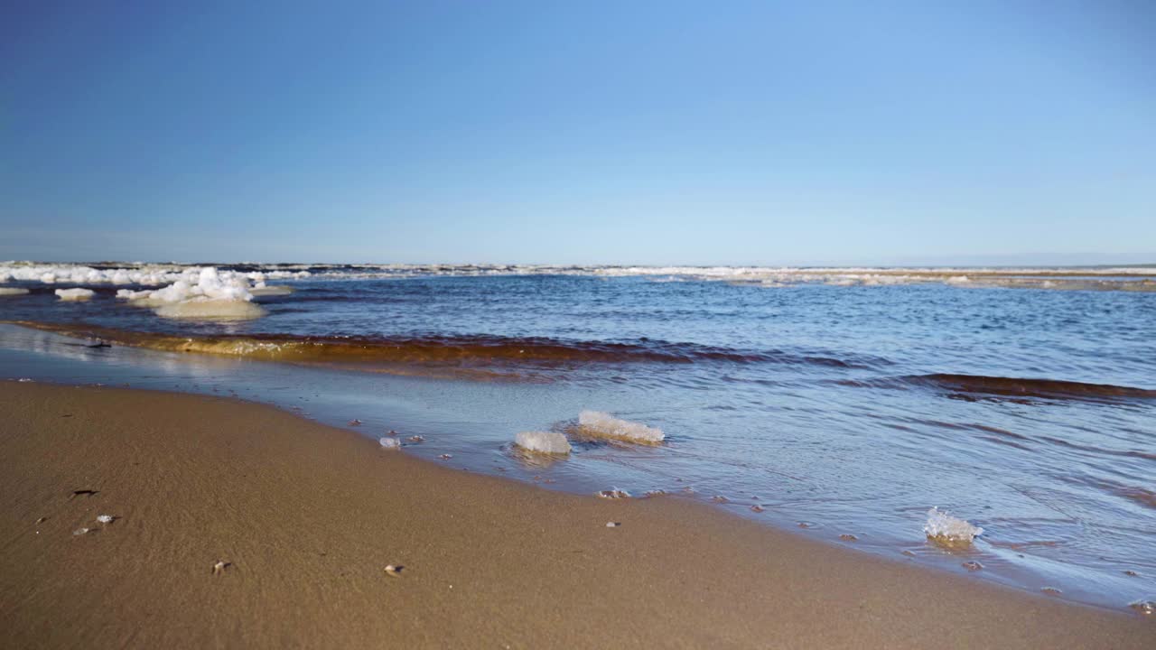 海浪拍打着波罗的海海滩上的冰块视频素材