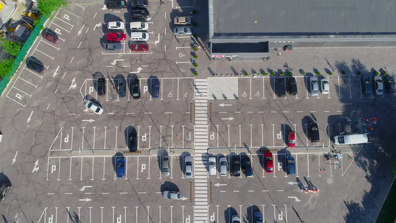 跨度超过一个停车场与汽车，停车场附近的商店俯视图视频素材