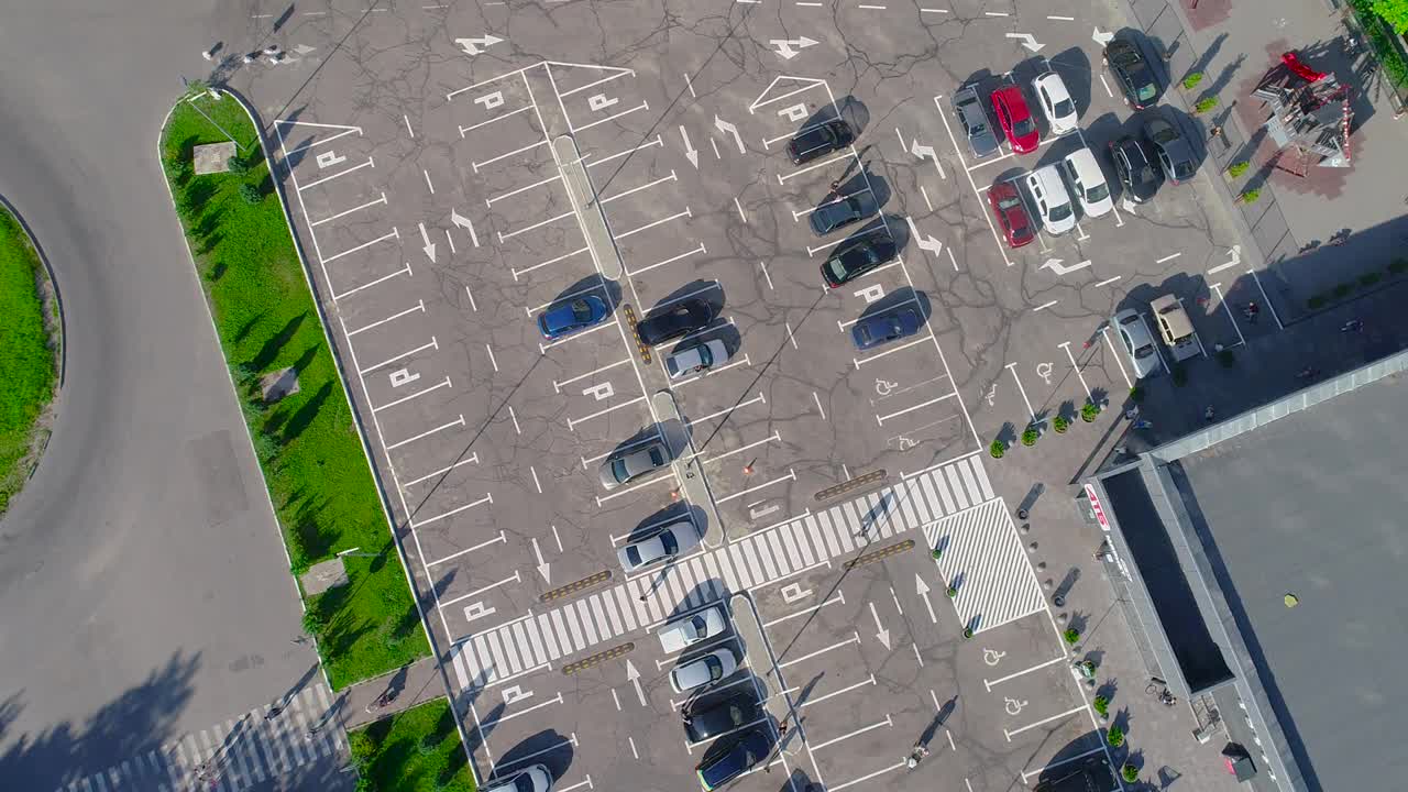 跨度超过一个停车场与汽车，停车场附近的商店俯视图视频素材