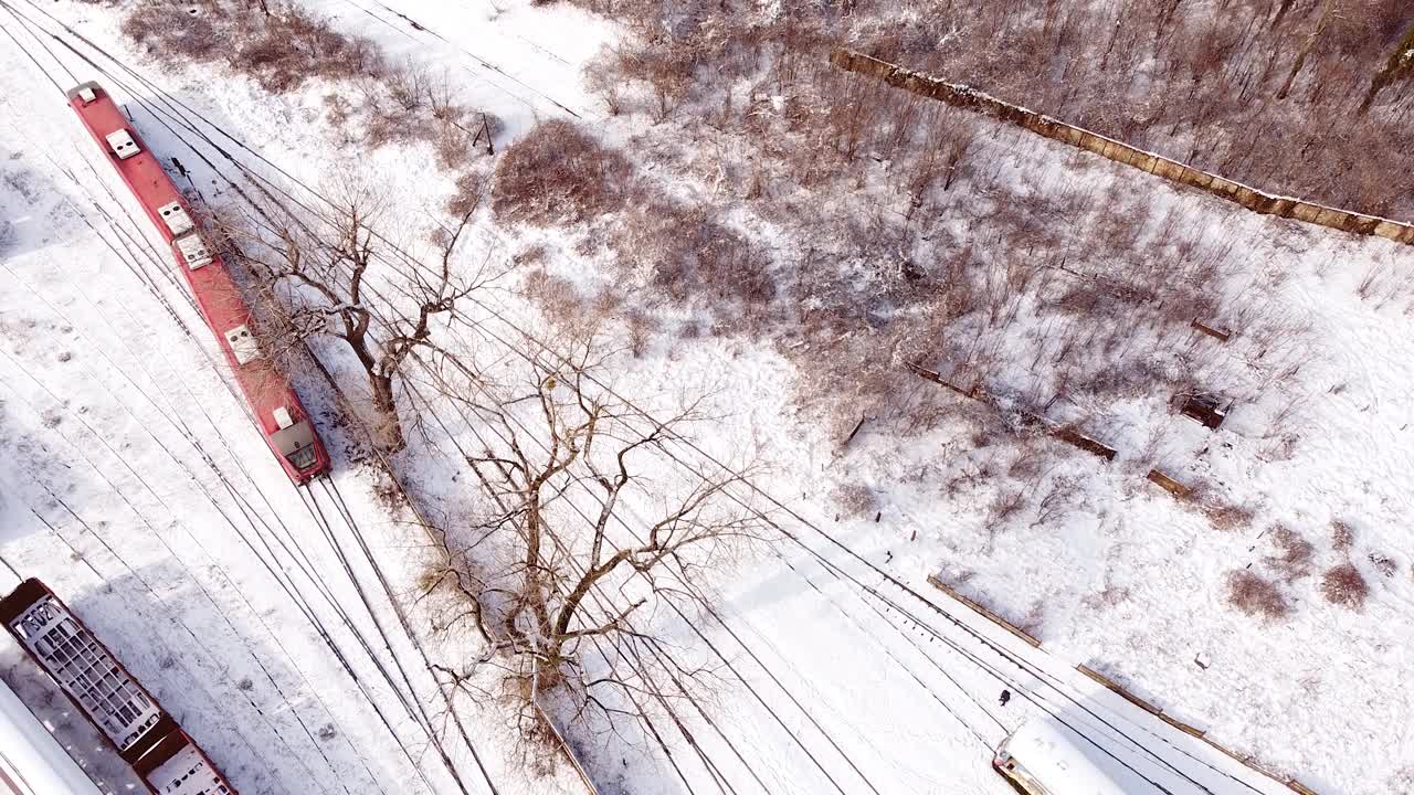 顶部鸟瞰图覆盖的铁路轨道与红色柴油客运列车离开现场。视频素材