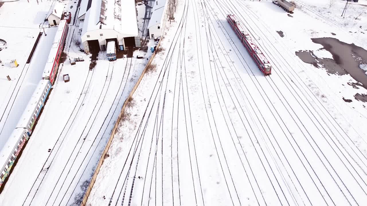 红色的柴油火车在火车站被雪覆盖着离开车站。视频素材