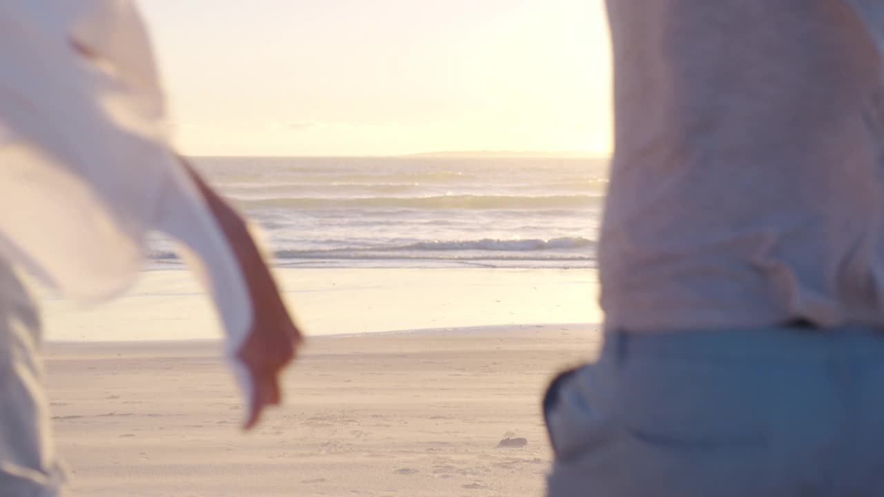 幸福的一家人在夕阳下的沙滩上散步。妈妈，爸爸和宝宝在日落时快乐地散步。共同家庭散步健康的生活方式。幸福家庭的概念和家庭价值观。视频素材