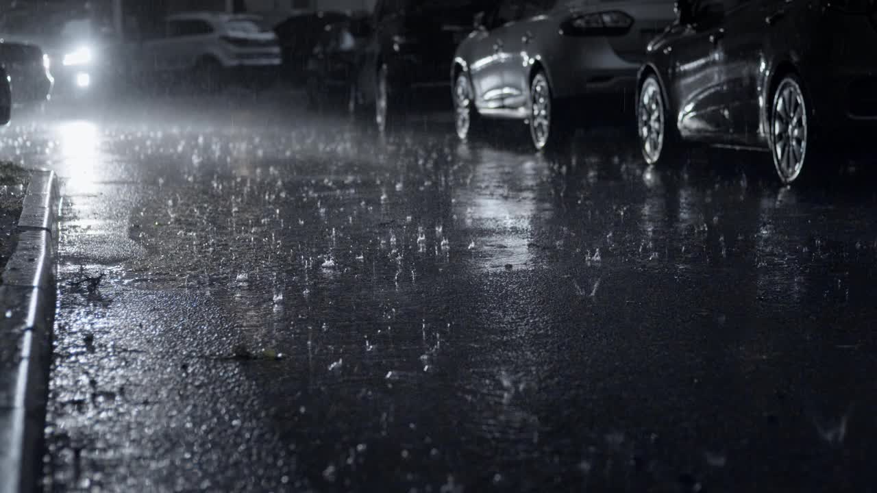 夜幕降临，城市的院子里下着倾盆大雨视频素材