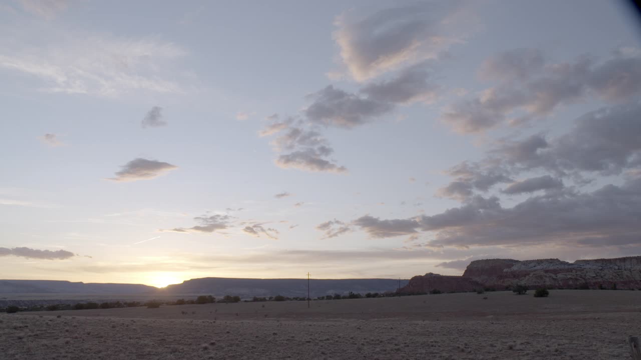 广角的沙漠景观日落在bg。看得见蓝天和白云。可见的山脉、高原或台地。美国西南部，可能是亚利桑那州。视频素材