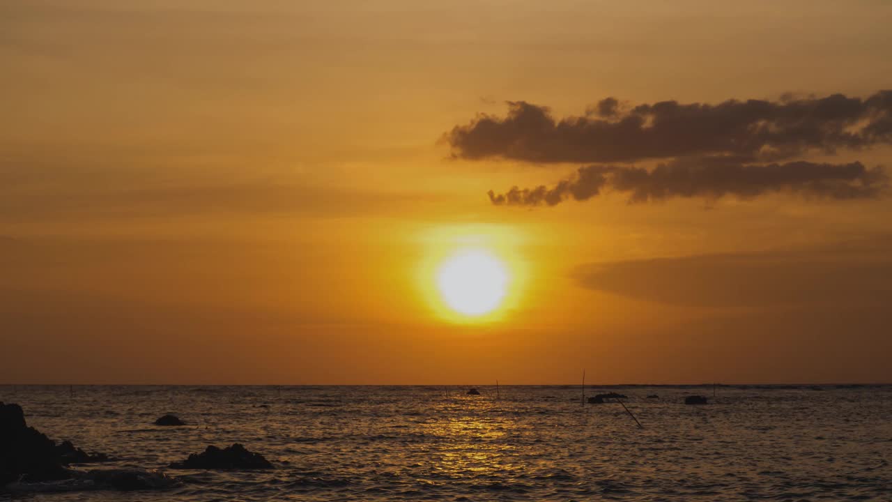 海外金色日落的时间流逝。在夏天的傍晚，圆形的橙色的太阳落入水中。景观自然日出背景。镜头b一卷太阳。黄色的日落的天空。美丽平静的海洋。视频素材