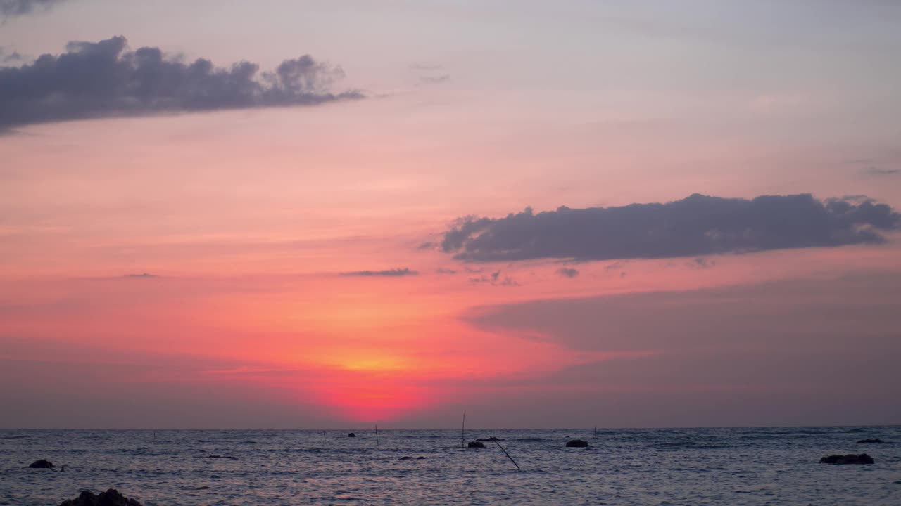 时间流逝的日落天空，橙色柔和的傍晚在夏季炎热的天气。乌云遮住了太阳。阳光穿过乌云。海面上的日落。旅行热带海滩和海洋视频素材