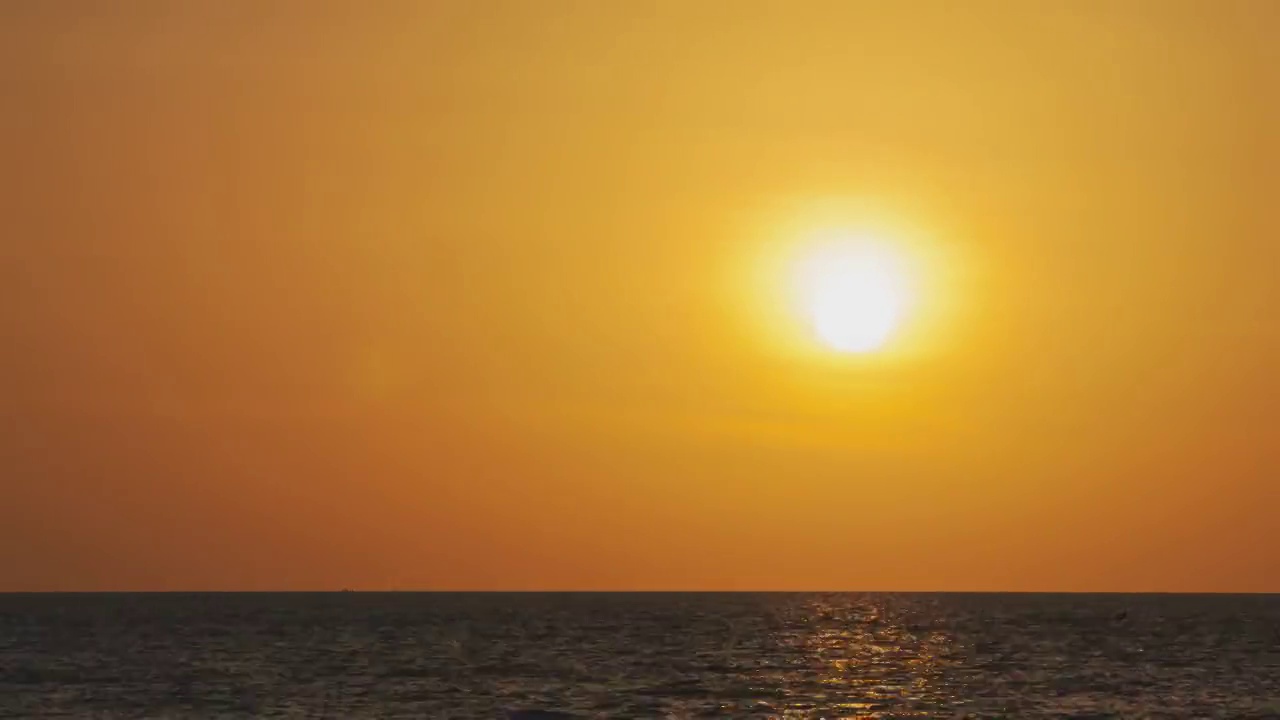 海外金色日落的时间流逝。在夏天的傍晚，圆形的橙色的太阳落入水中。景观自然日出背景。镜头b一卷太阳。黄色的日落的天空。美丽平静的海洋。视频素材