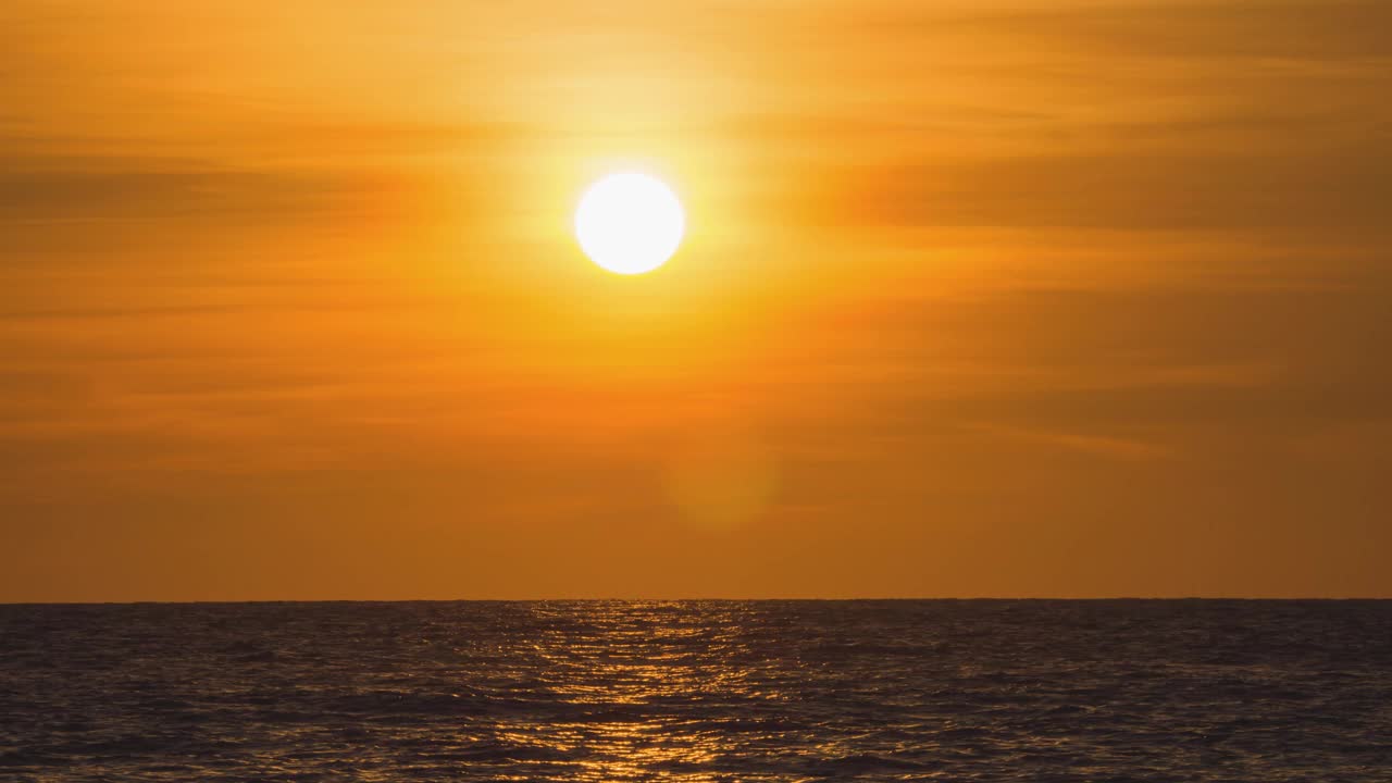 海外金色日落的时间流逝。在夏天的傍晚，圆形的橙色的太阳落入水中。景观自然日出背景。镜头b一卷太阳。黄色的日落的天空。美丽平静的海洋。视频素材