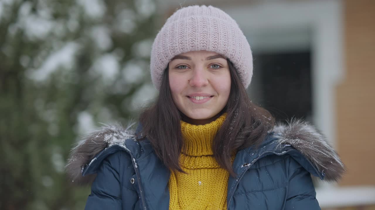 雪球打在美丽的年轻白人妇女的脸在慢动作。肖像笑快乐迷人的女士有乐趣的户外打雪球。休闲和放松的概念。视频素材