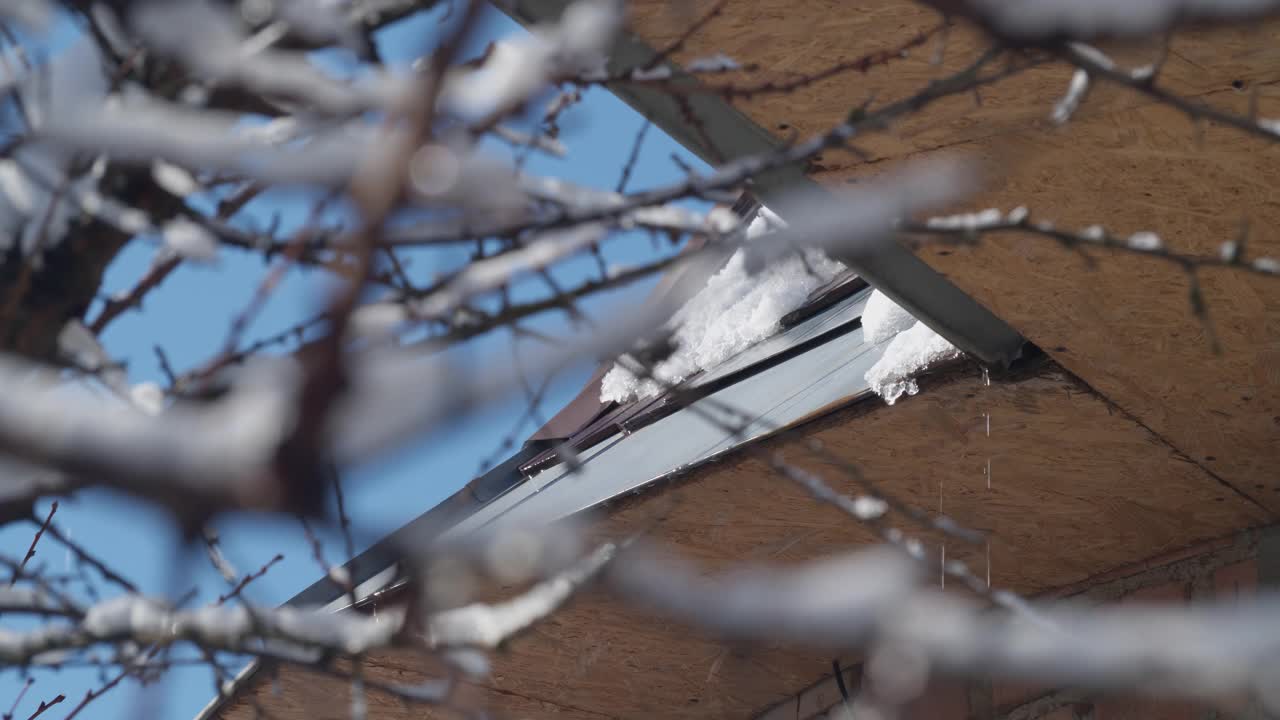 屋顶上挂着冰柱，映衬着蓝色的天空视频素材