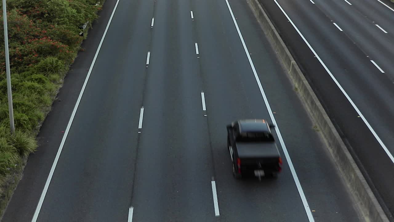 慢镜头高速公路夕阳下的交通和城市天际线视频素材