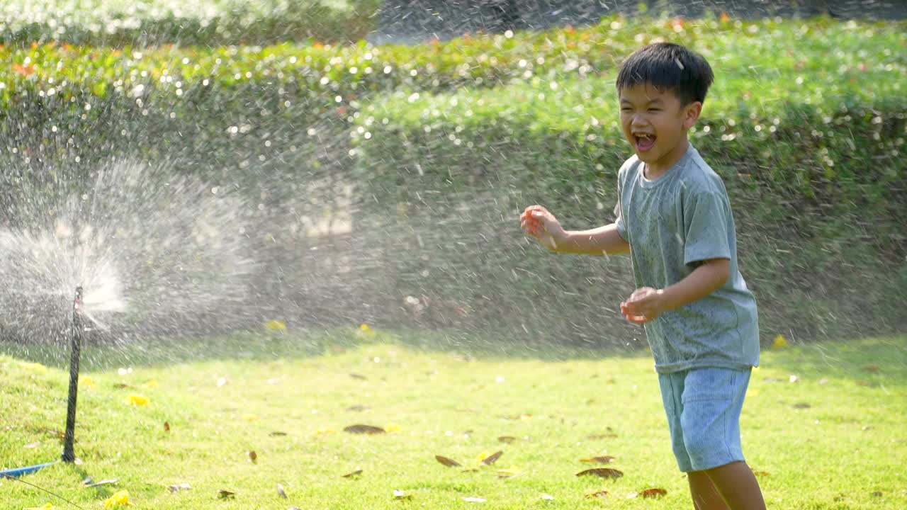 亚洲小孩在公园玩溅水游戏。夏天和快乐的概念视频素材