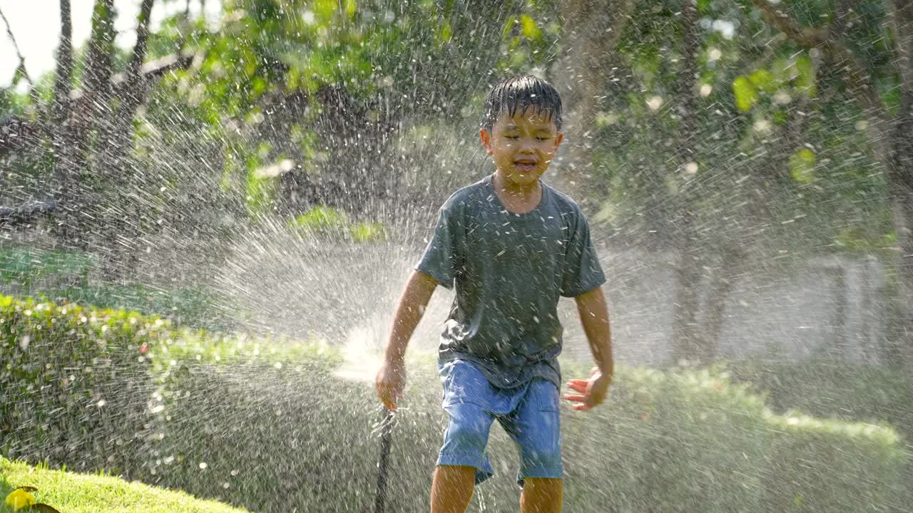 亚洲小孩在公园玩溅水游戏。夏天和快乐的概念视频素材