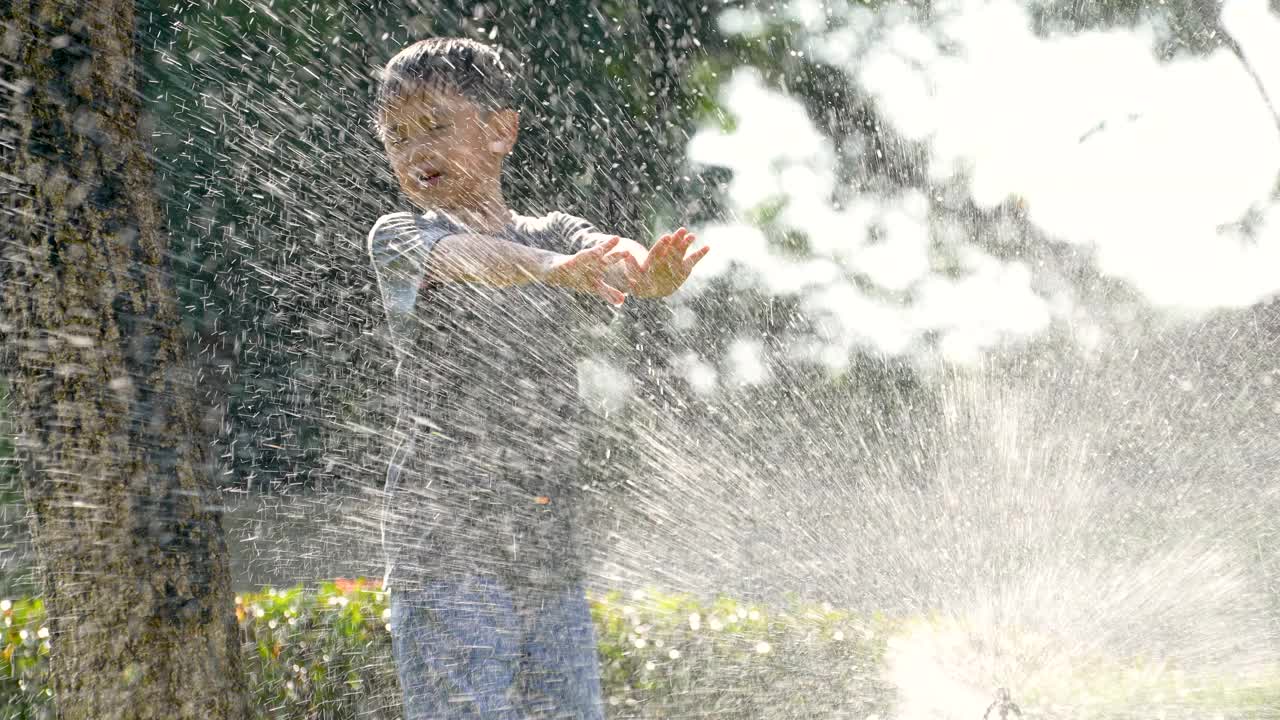 亚洲小孩在公园玩溅水游戏。夏天和快乐的概念视频素材