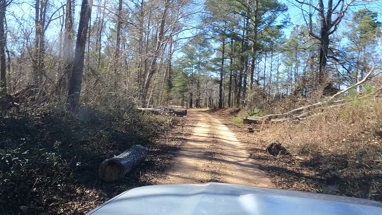 4x4驾驶在泥土路通过砍倒的树视频素材