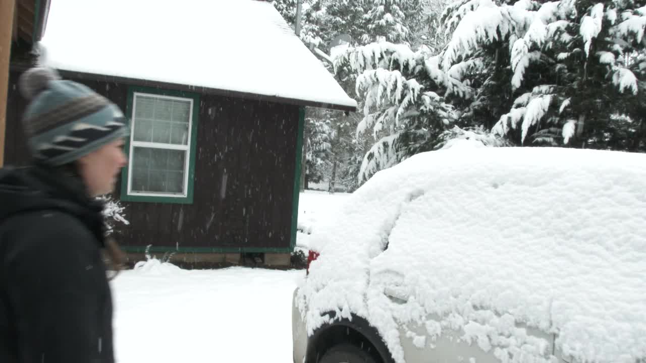 女人刷掉车上的大雪视频素材