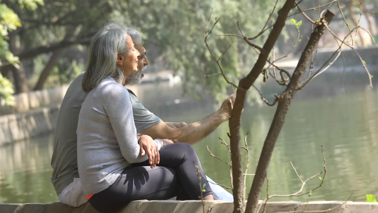 相爱的老年夫妇在湖边度过闲暇时光视频素材