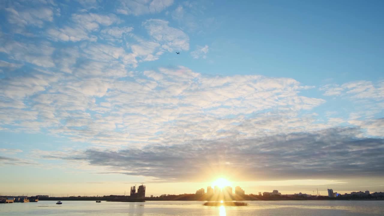 在多云的天空下，河边高楼林立的现代城市视频素材