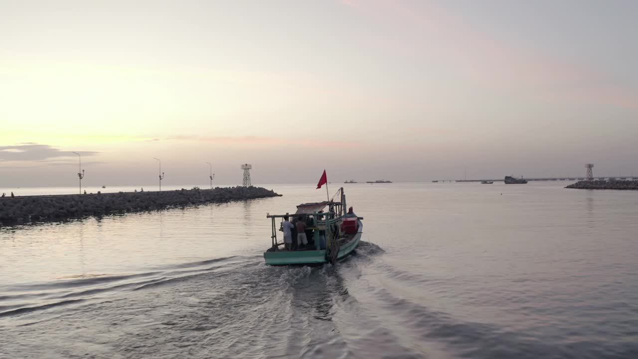 日落时分驶离港口的渔船视频素材