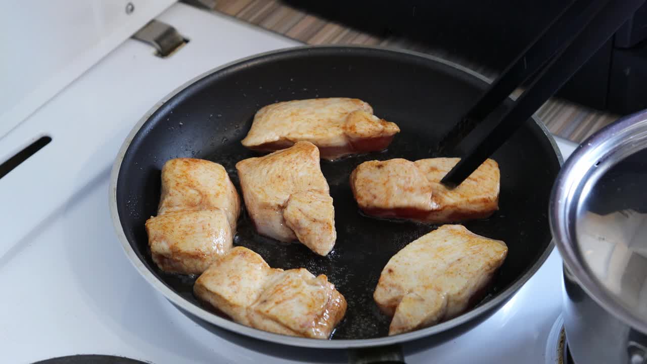 在平底锅里油炸和混合鸡肉的特写镜头。浅的焦点。视频素材