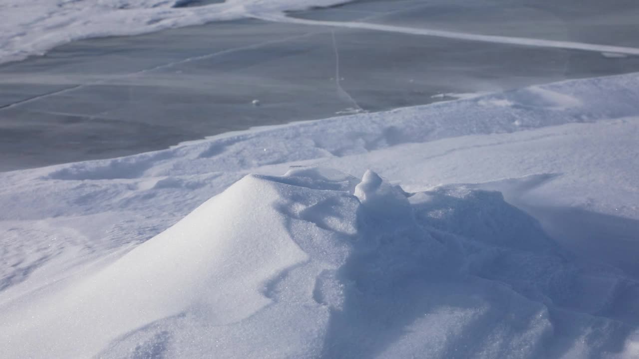 白雪在贝加尔湖的蓝色冰面上飞舞视频素材