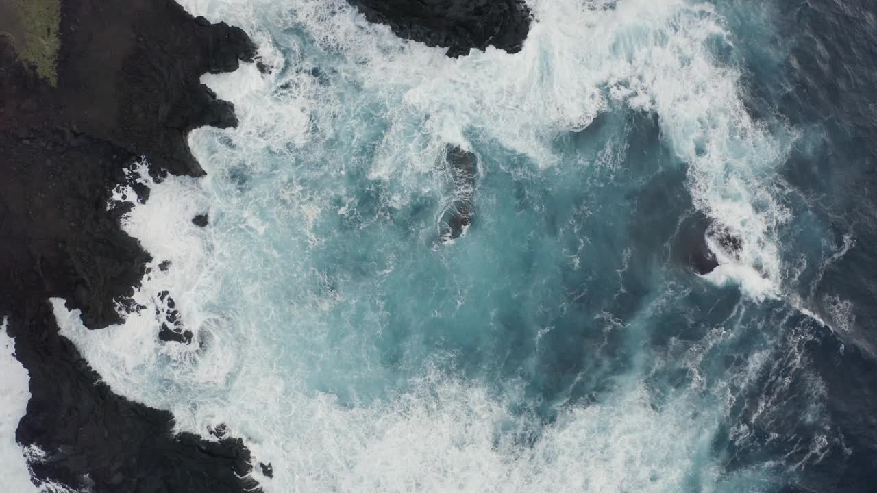 鸟瞰图，脆脆的海浪拍打着岩石。视频素材