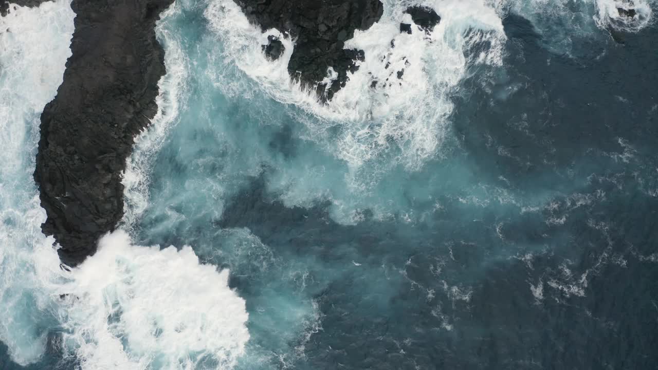 鸟瞰图，脆脆的海浪拍打着岩石。视频素材