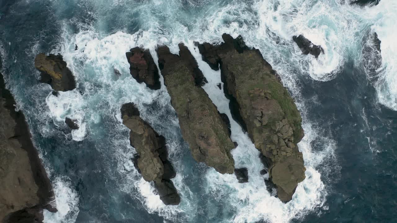 鸟瞰图，脆脆的海浪拍打着岩石。视频素材