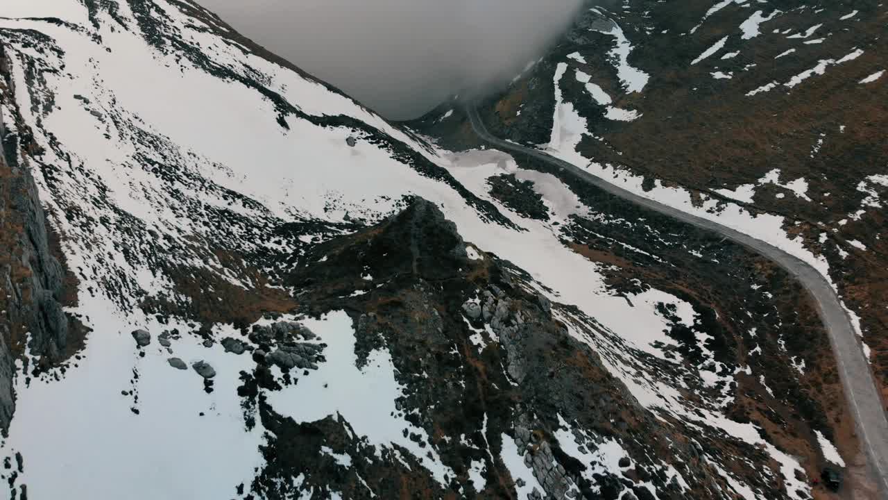 无人机拍摄的雪山港口中间的道路。多云有雾的一天。视频素材