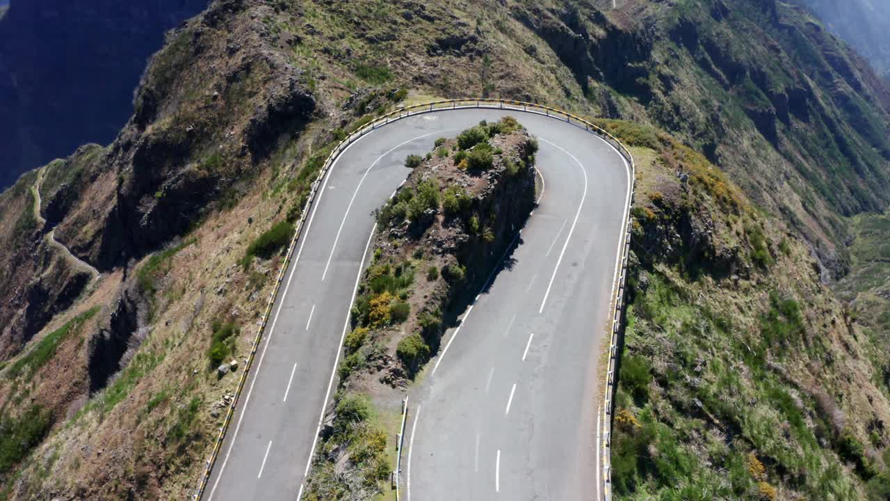 4K加速无人机拍摄的小型白色家庭汽车通过山区道路的弯道视频素材