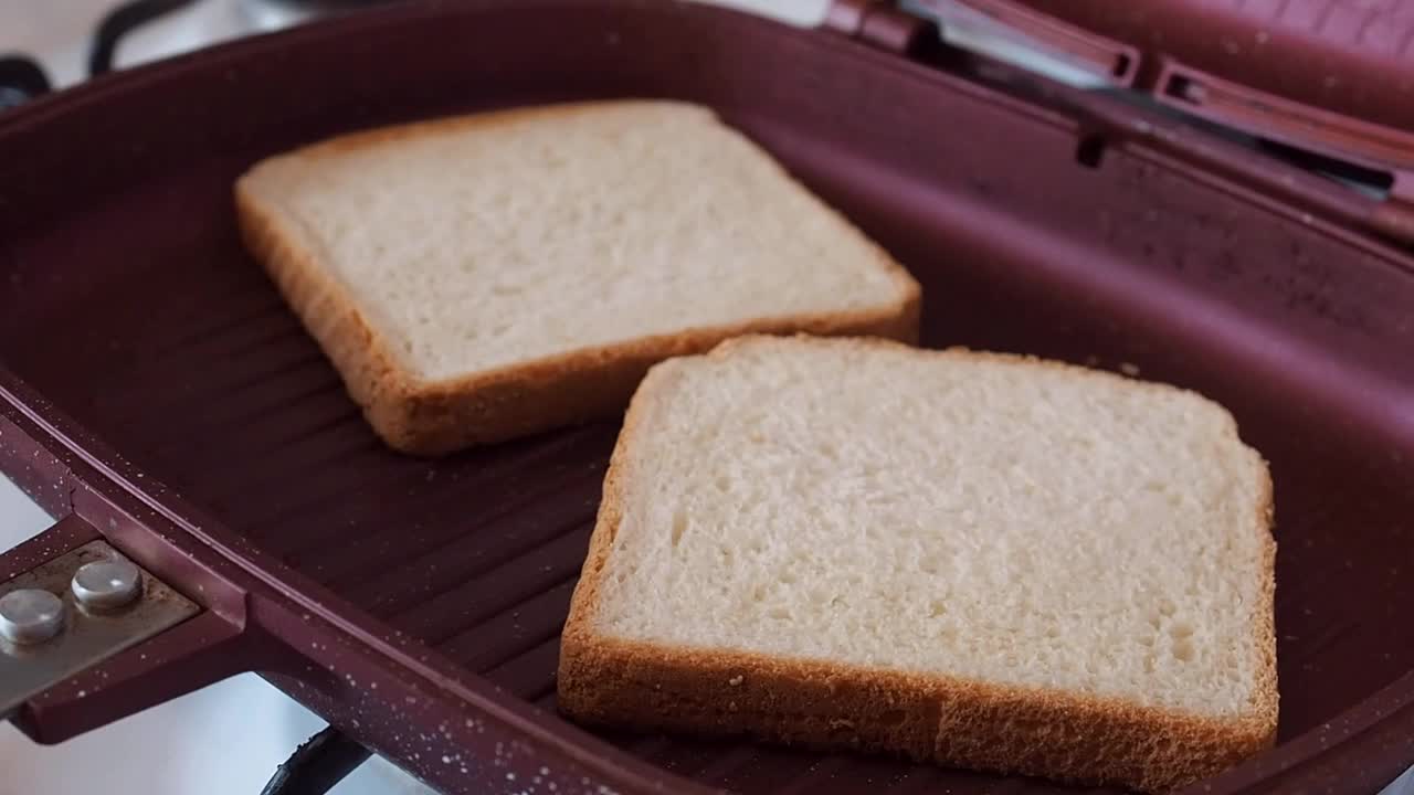 在烤三明治锅里做酥脆的吐司面包。视频素材