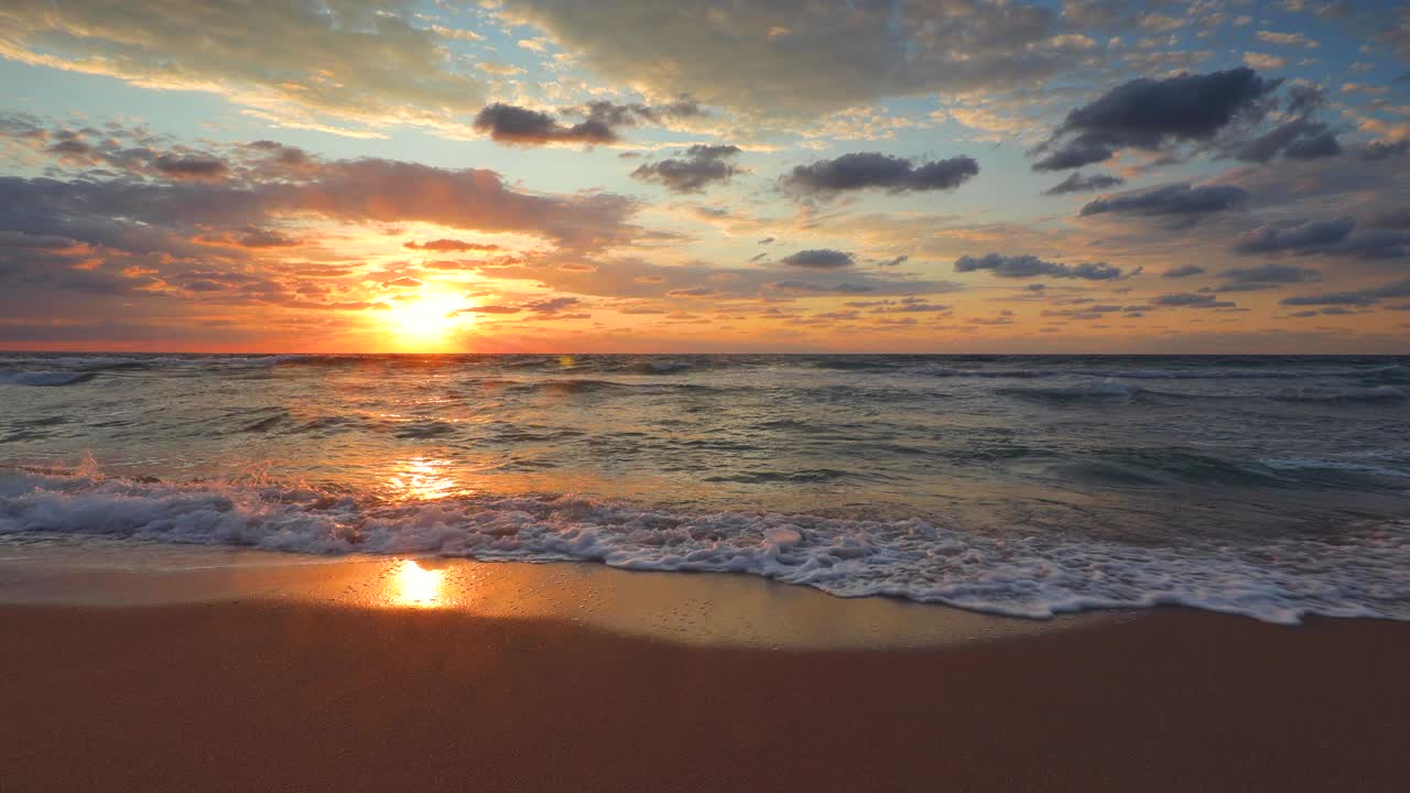 海洋日出和异国情调的海滩。海浪。燃烧的天空和闪耀的金色涟漪的水。4 k的视频视频素材