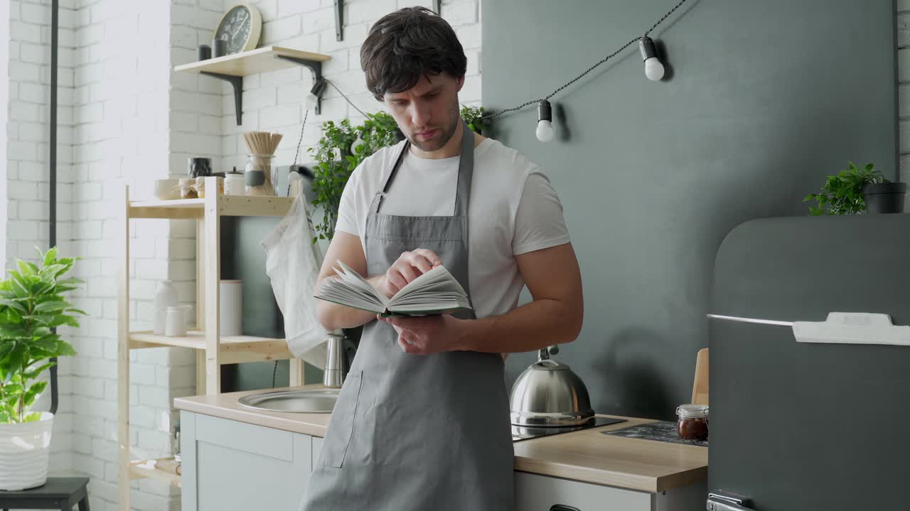 男人在厨房烹饪阅读食谱烹饪书视频素材