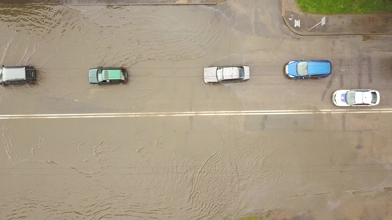 交通车辆在被雨水淹没的道路上行驶的鸟瞰图。视频素材