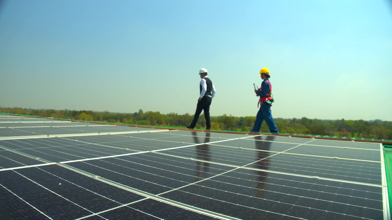 工程师和技术员检查太阳能电池板在太阳能农场的屋顶上产生可再生电力到工厂。环保、清洁能源、未来可再生能源、替代能源的概念视频素材