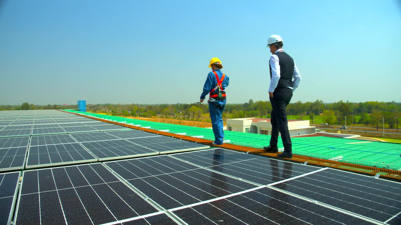 工程师和技术人员在屋顶工厂的太阳能农场检查太阳能电池板的运行系统。环保、清洁能源、未来可再生能源、替代能源的概念。视频素材