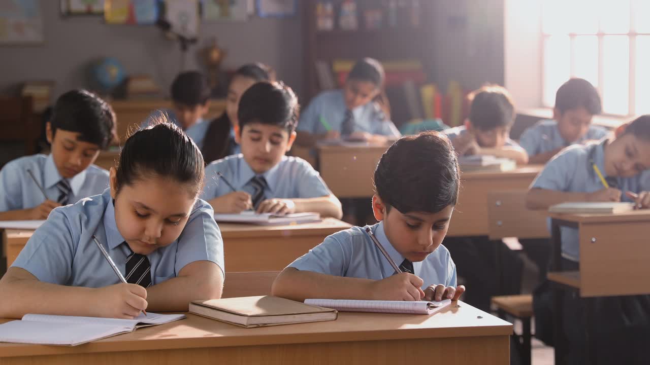 在教室里学习的学生在笔记本上写的中等镜头视频素材