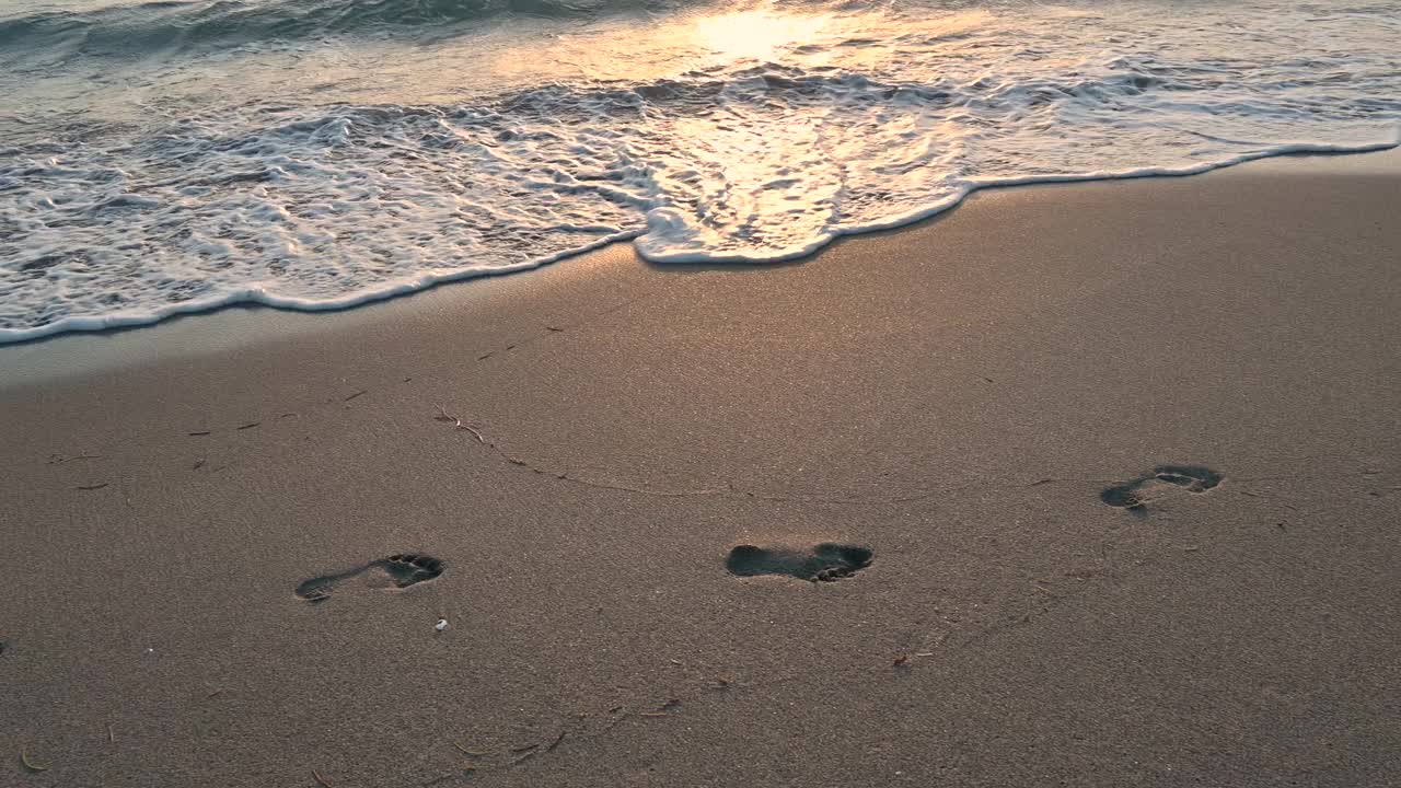 日落时，海浪冲刷着沙滩上的脚印，美国佛罗里达州博卡拉顿视频素材