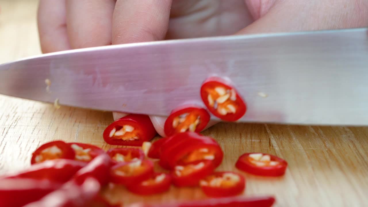 俯视图拍摄的女人在厨房准备食物的木板上切红辣椒视频素材