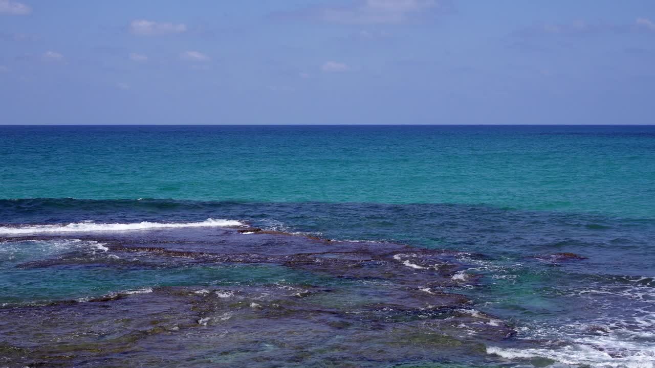 晴天的海景。海水拍打着地中海上发霉的岩石视频素材