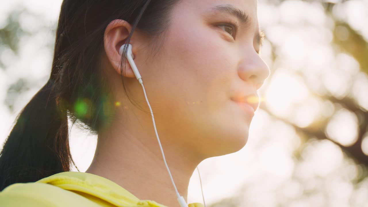 亚洲女运动员在城市的街道上跑步后喝瓶装水。视频素材