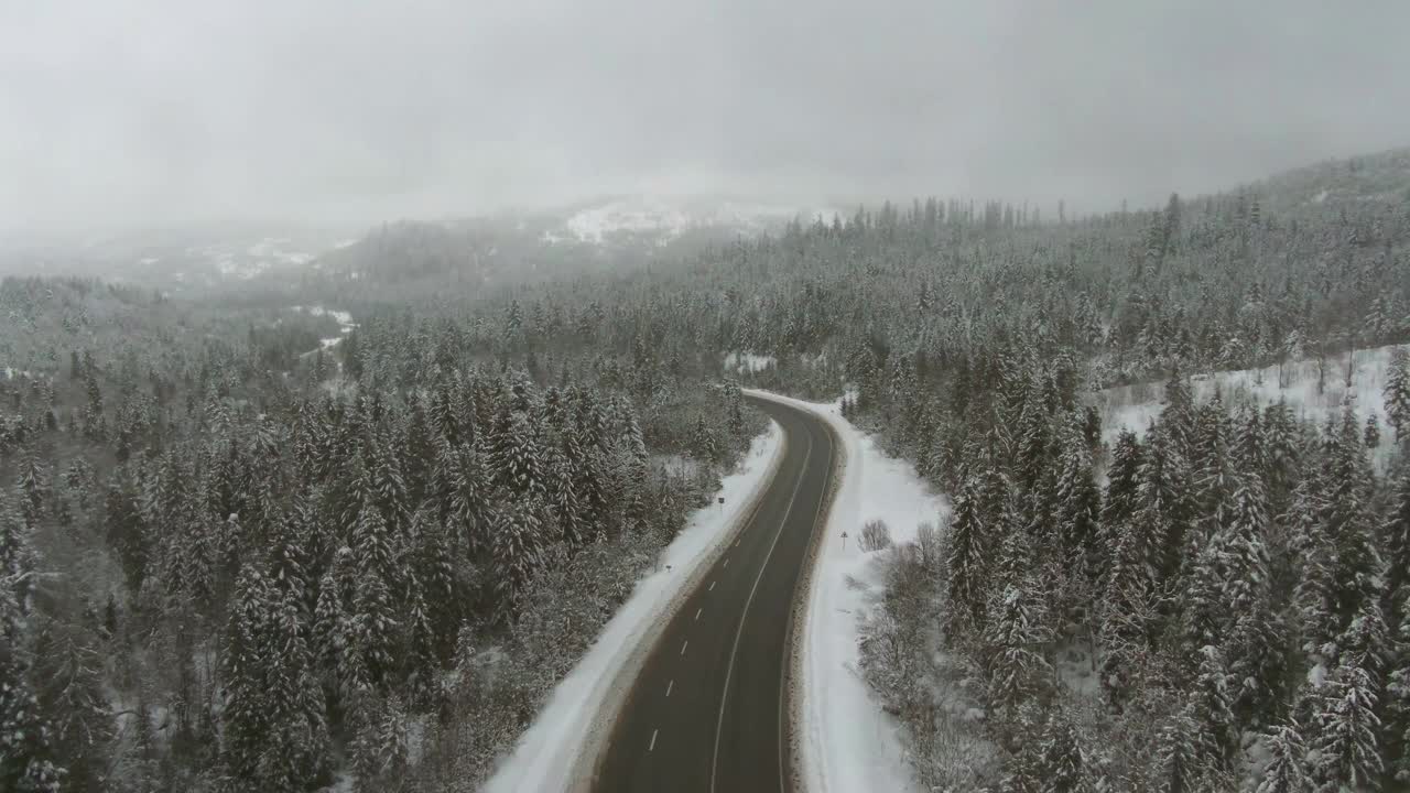 在高速公路上行驶的卡车和雾蒙蒙的雪山的背景-鸟瞰图视频素材