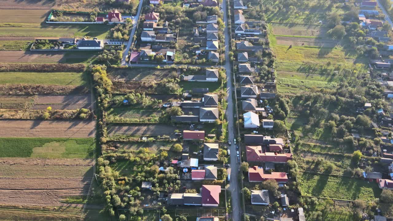 从高处鸟瞰美丽的乡村村庄，有房子和街道在犁地，草地视频素材