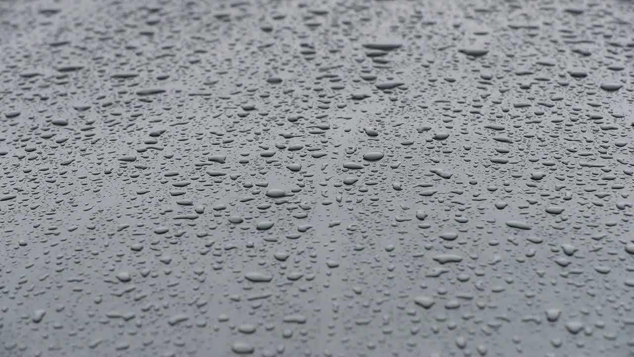 雨点落在汽车引擎盖上。视频素材