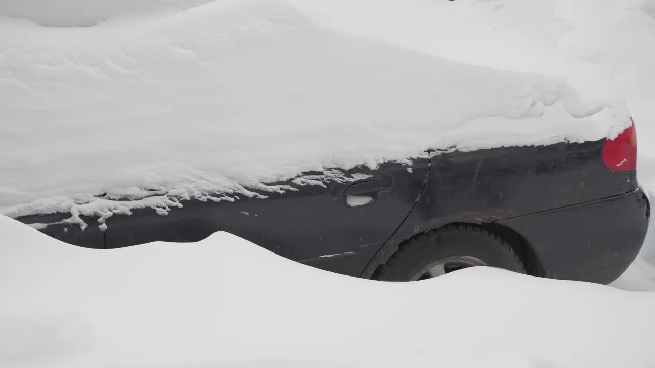 车有点生锈，完全被雪覆盖了。冬季气旋的概念视频素材