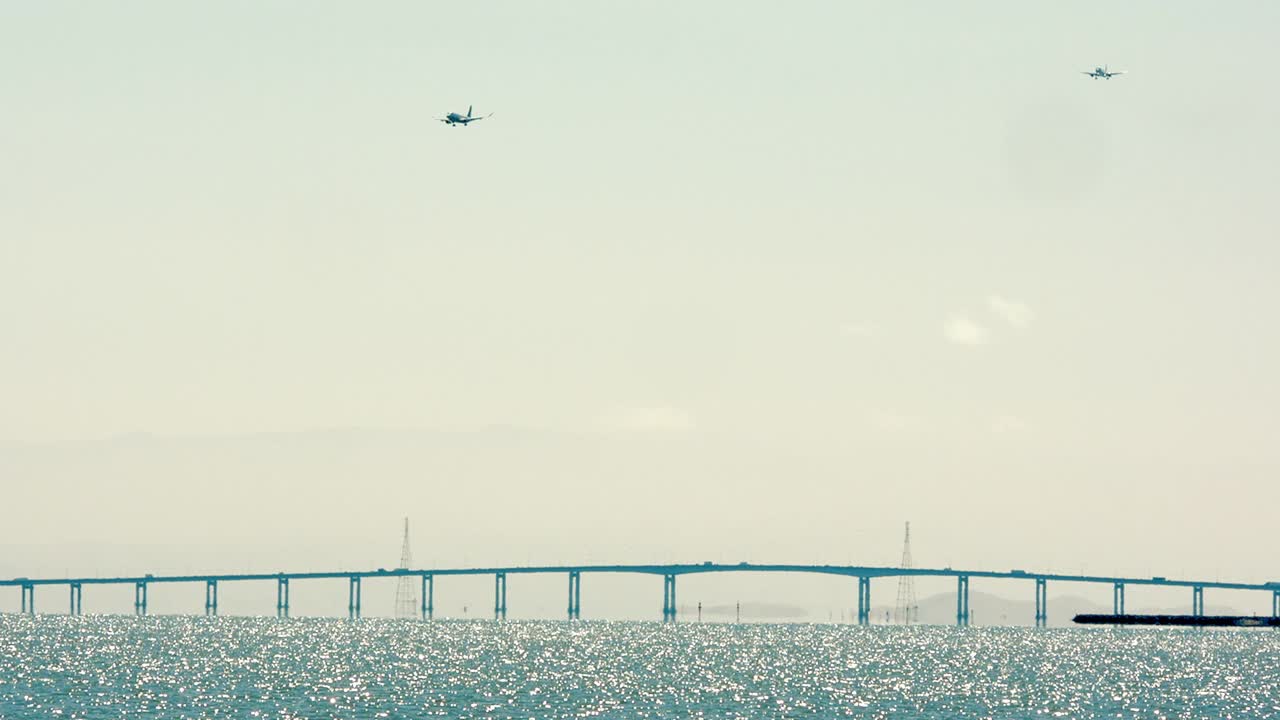 2架飞机在圣马特奥-海沃德大桥上空最后进场视频素材