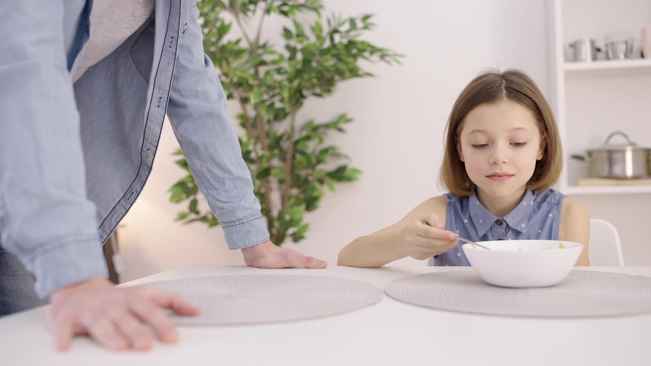 恼怒的父亲对女儿说话，让孩子早上吃燕麦片视频素材