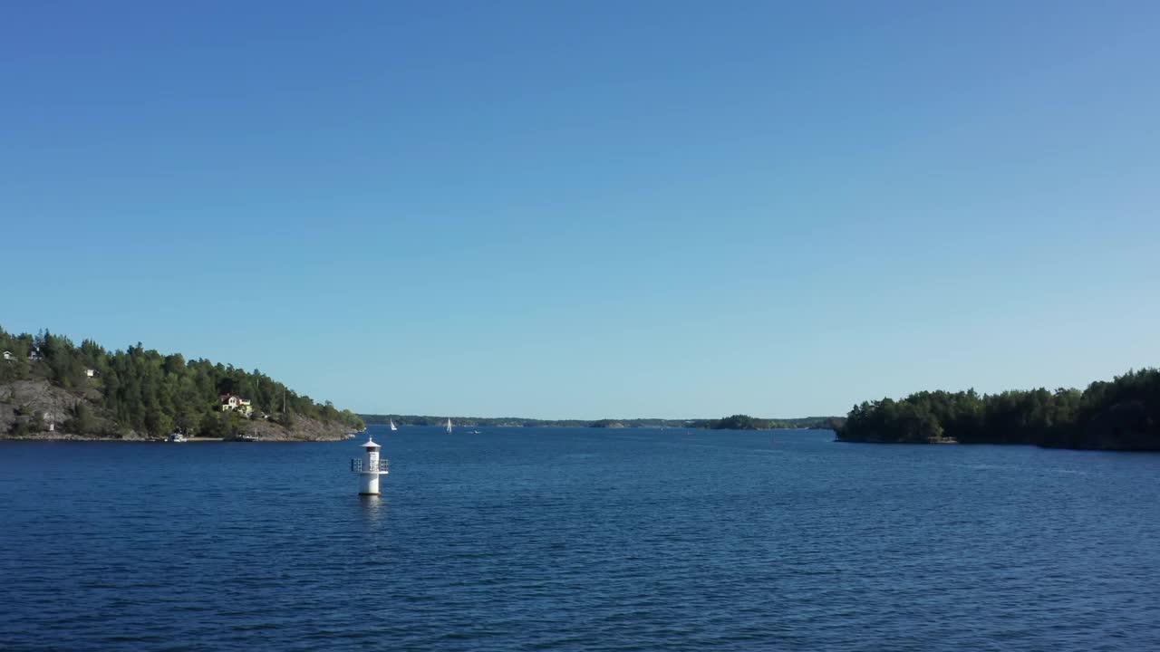 位于北欧斯堪的纳维亚群岛的灯塔或灯塔。夏日的空中飞过水面和岩石岛屿视频素材