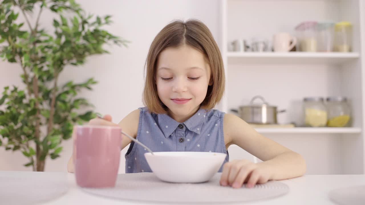 快乐女孩早上吃健康早餐，喝茶，营养丰富视频素材