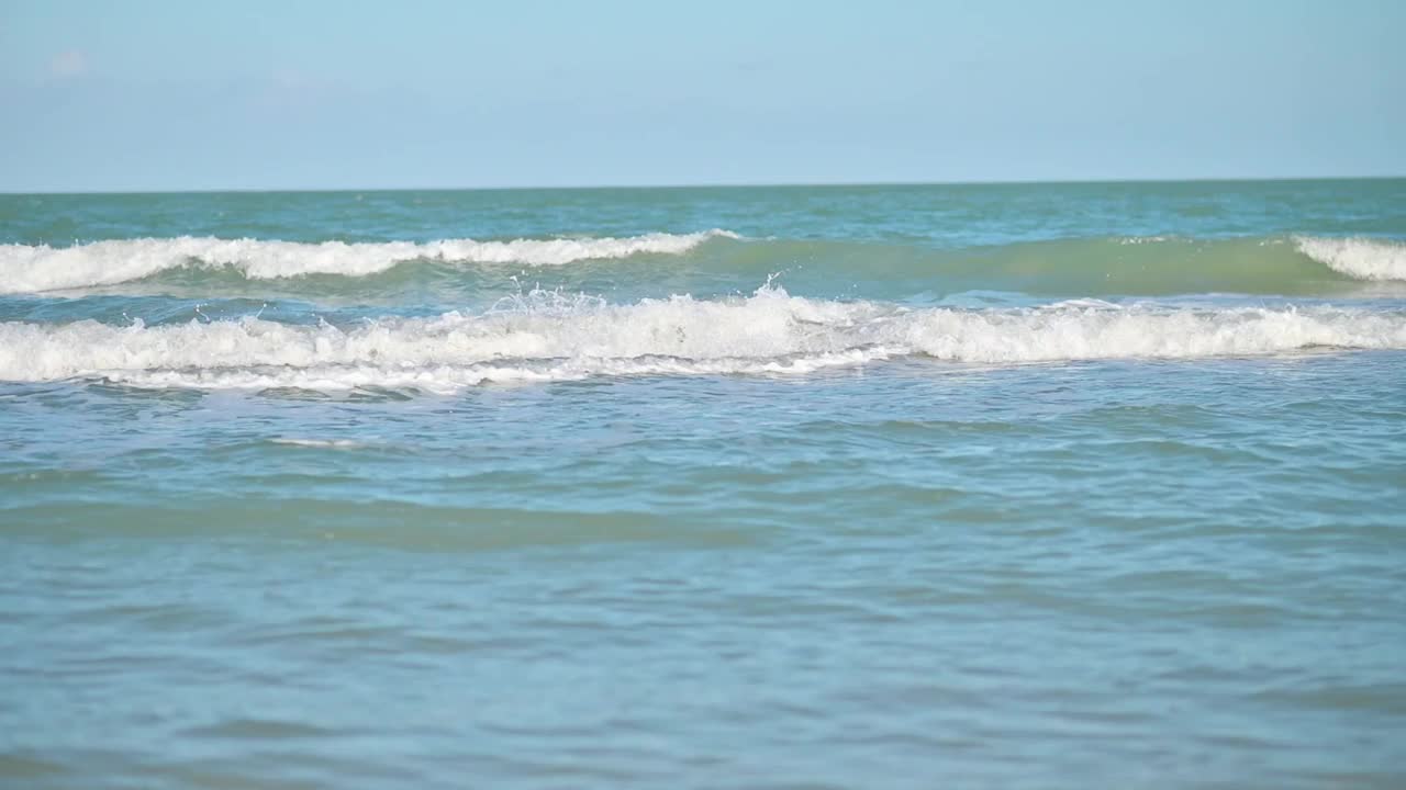 在晴朗的天气里接近海岸的海浪。视频素材